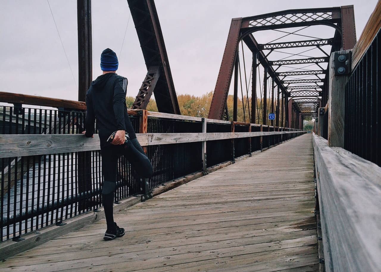 man stretching his legs before a run