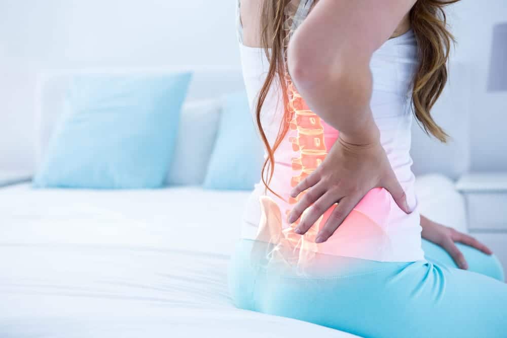 female patient holding her lower back due to pain