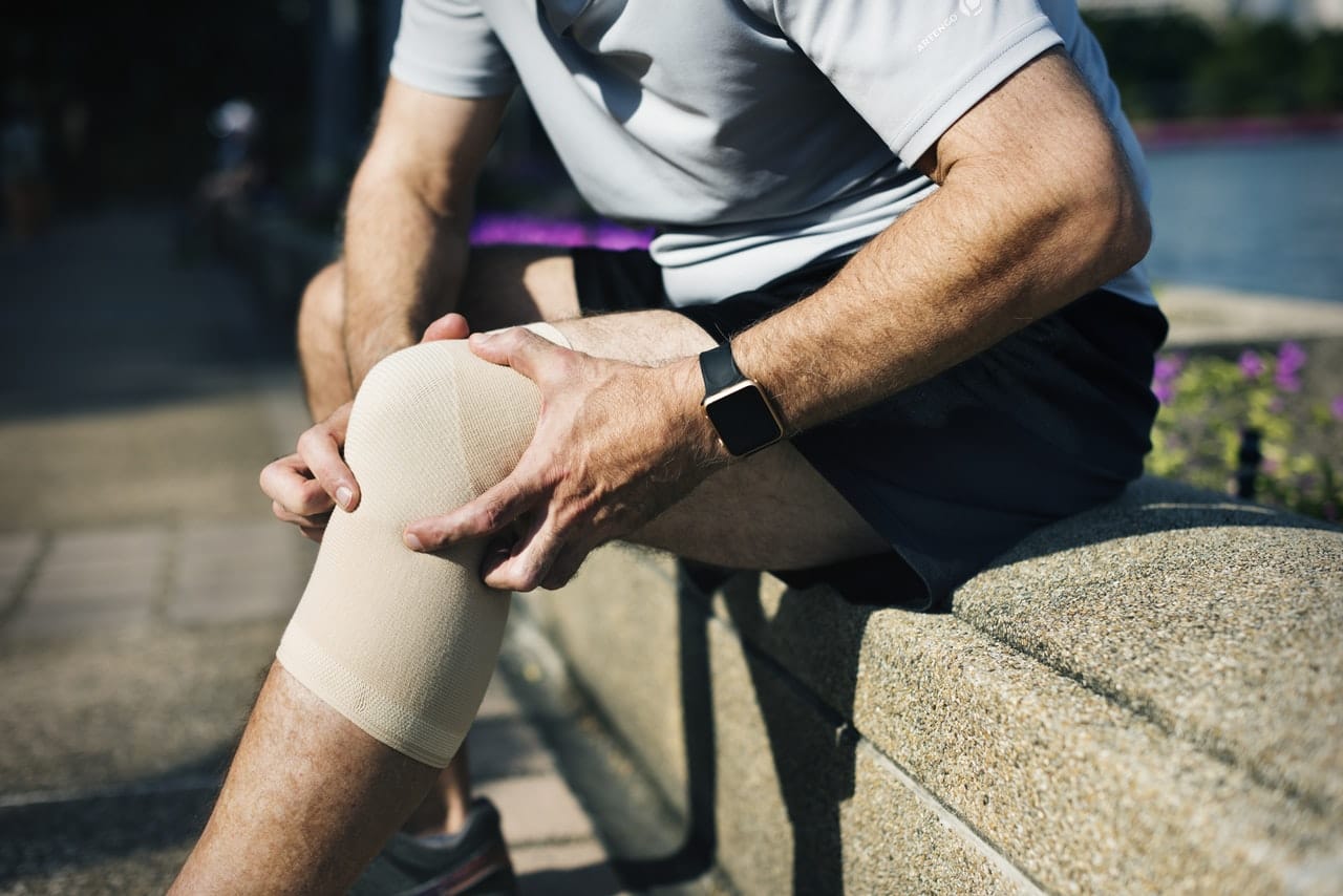 man holding his knee due to pain