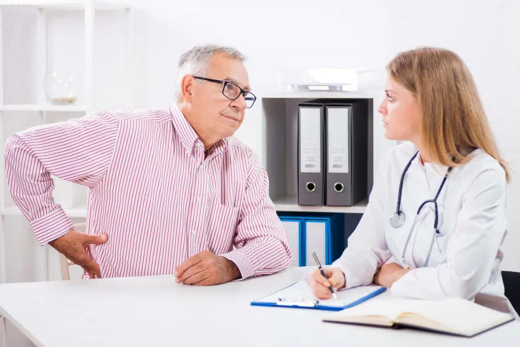 Older male patient speaking to his doctor