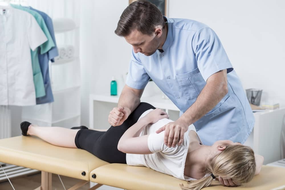 chiropractor adjusting female patient