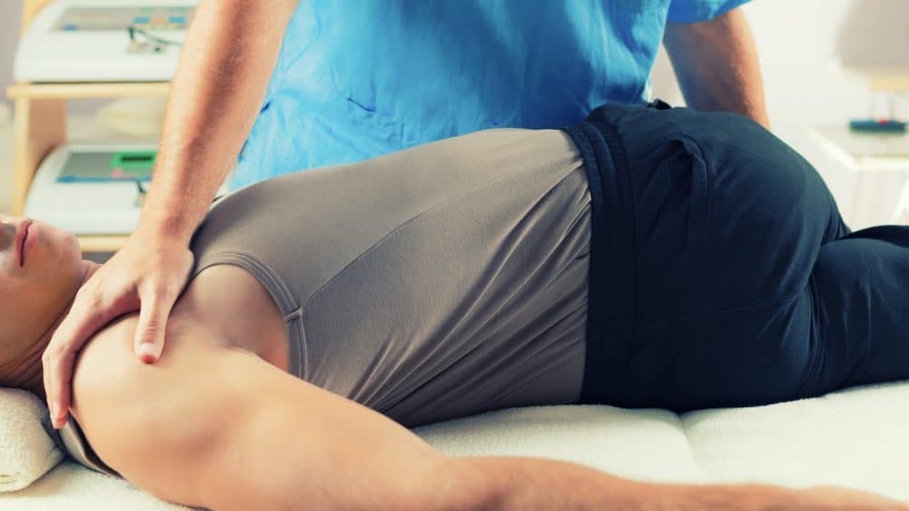 chiropractor adjusting patients back
