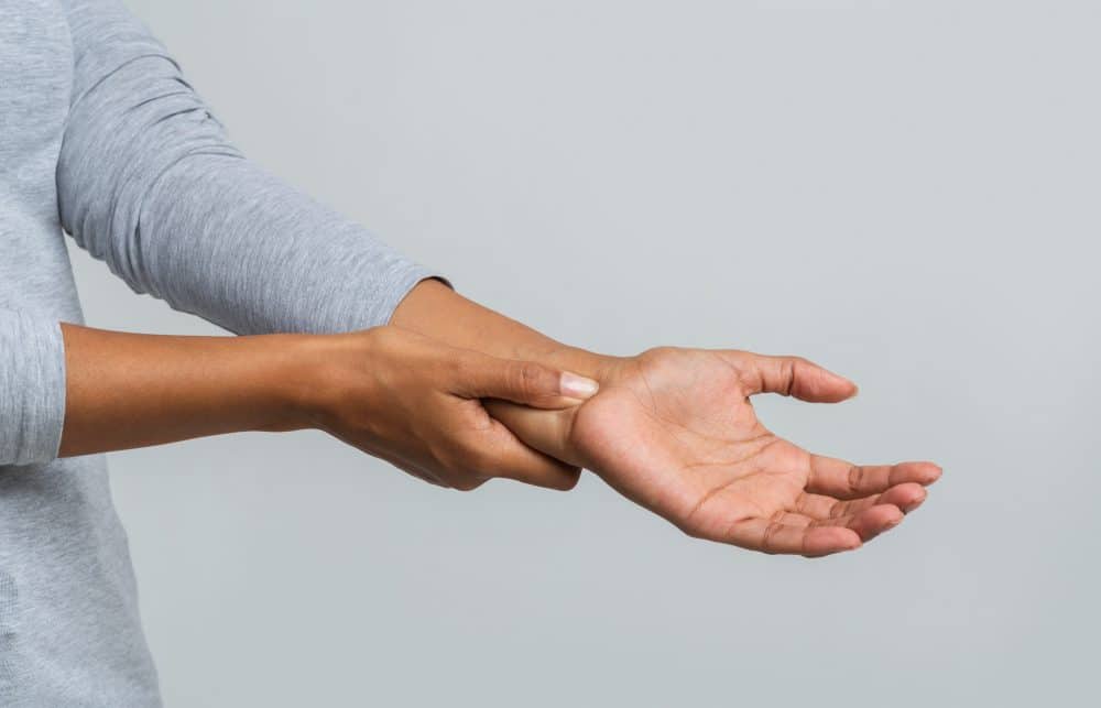 woman holding her wrist due to pain