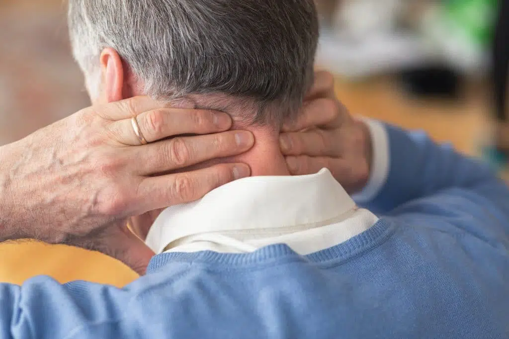 Elderly man holding his neck due to pain