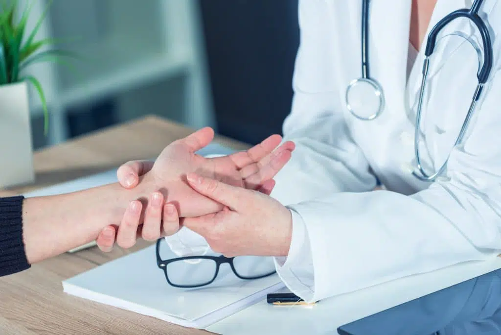 Doctor examining a patient's hand and wrist.