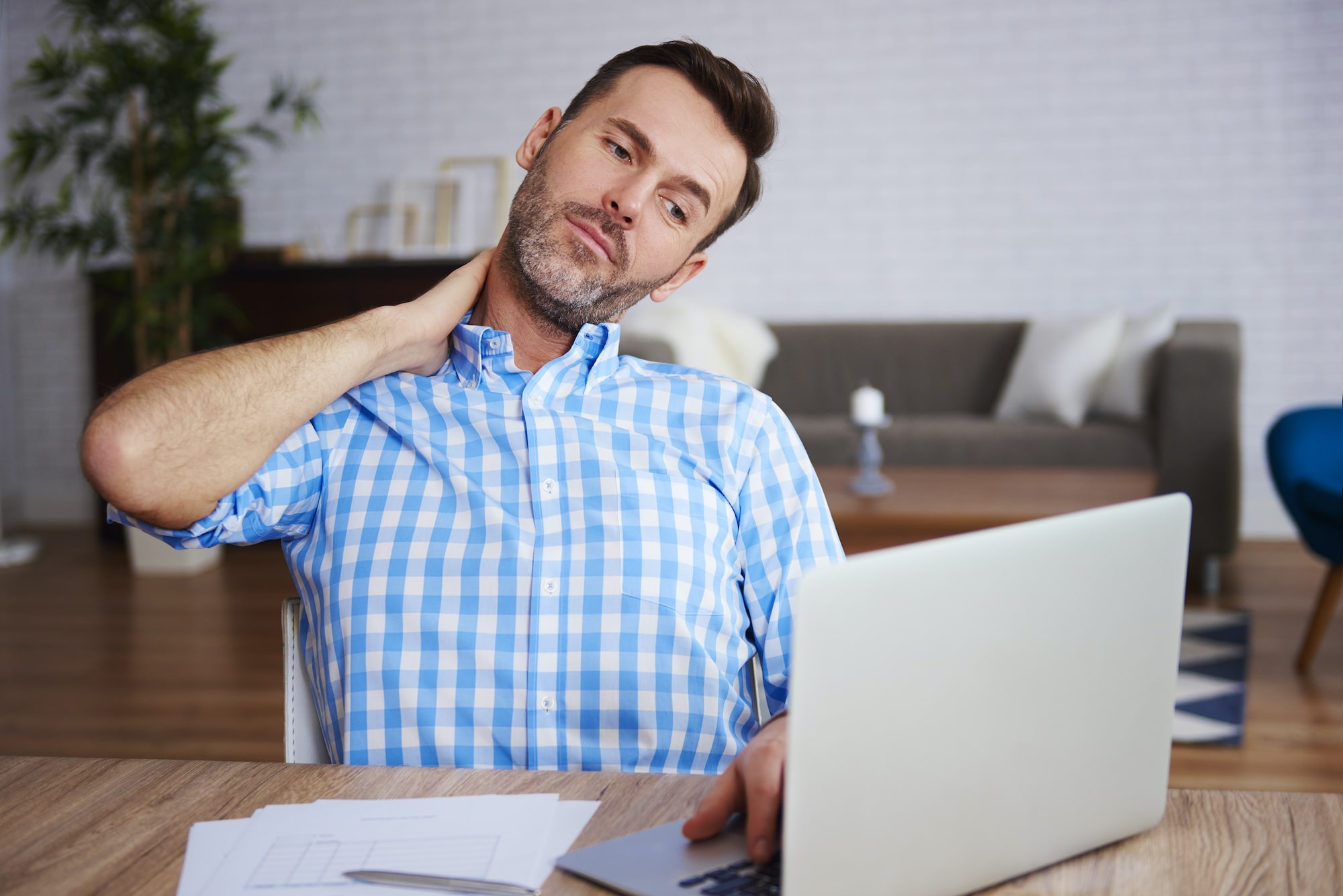 Young man holding his neck due to pain