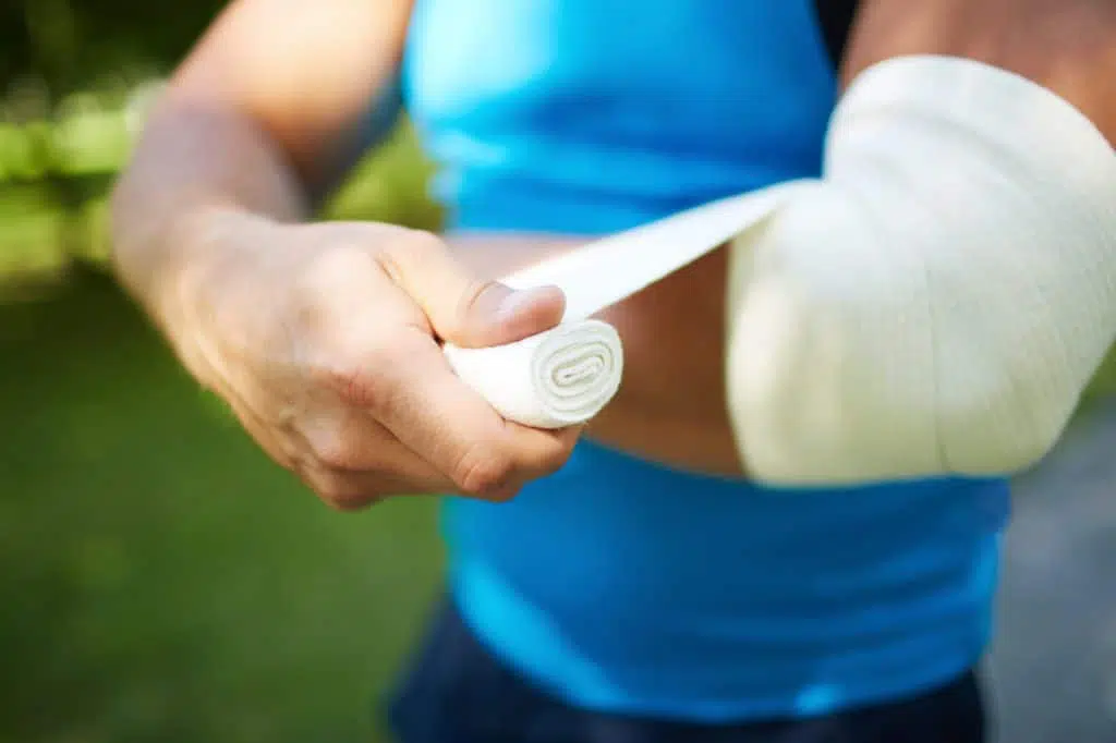 Tennis player bandaging his elbow due to pain.