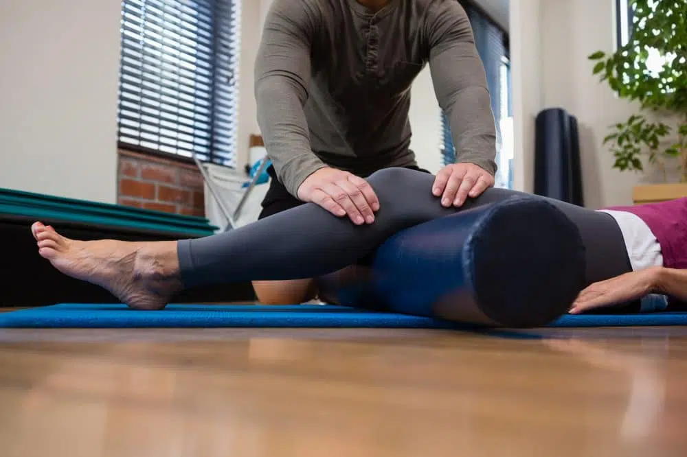 Physical therapist treating a patient with leg pain.