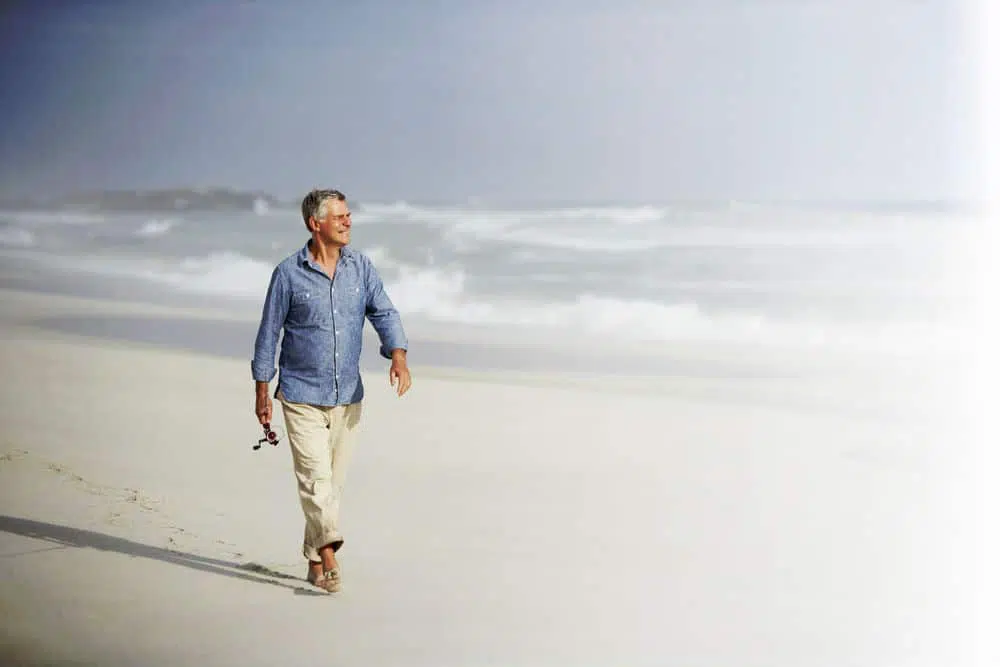Man walking at the beach relieved from pain.