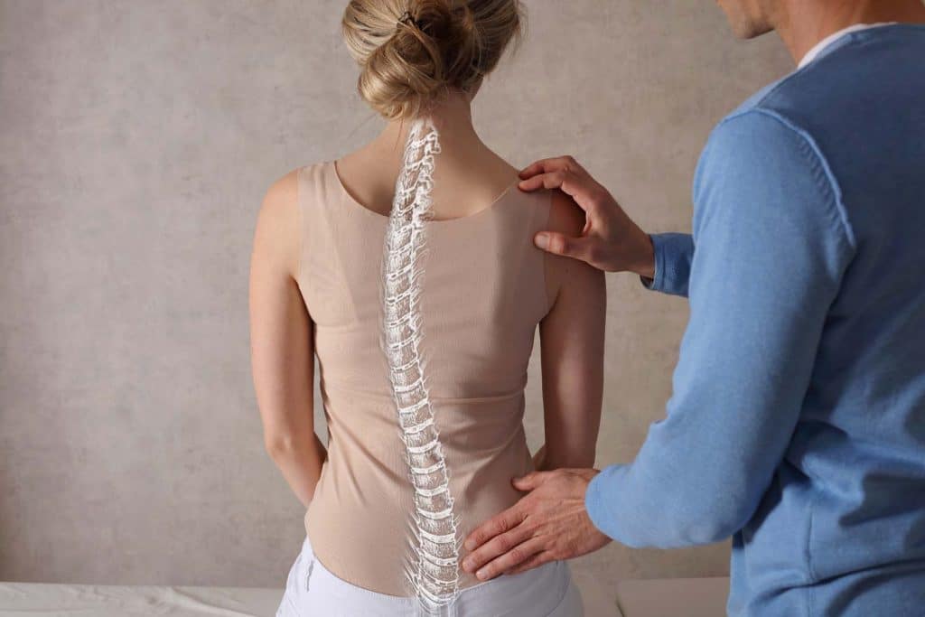 Doctor examining a patient's back for spine surgery.