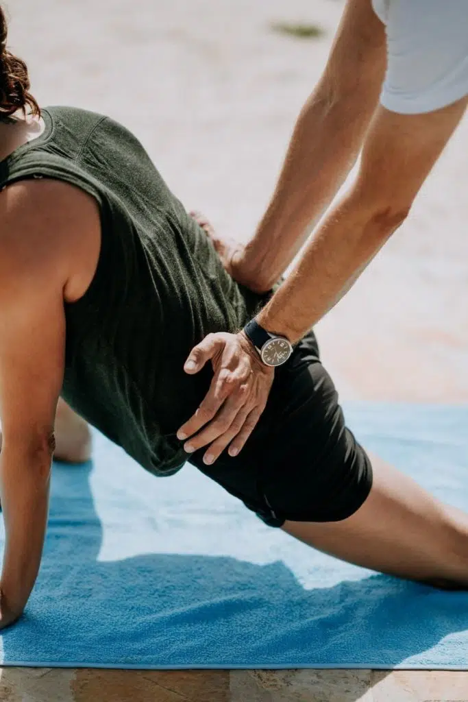 Patient performing hip exercise with a sports medicine doctor.